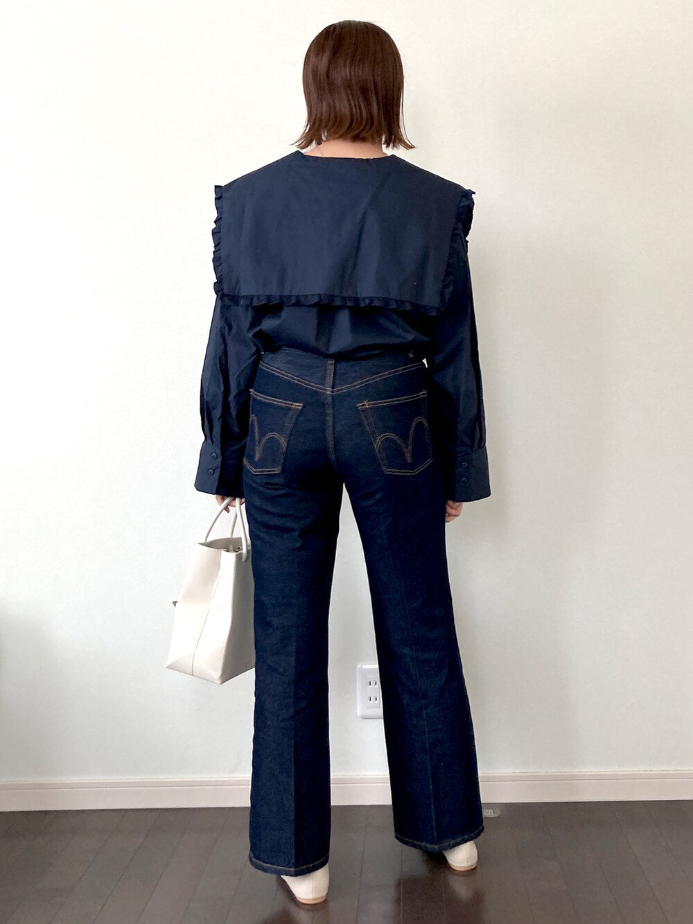 ブルー系のシャツ/ブラウス、ベージュ系のショルダーバッグ、ブルー系のデニムパンツを着用したレディースの春コーディネートの3枚目の写真