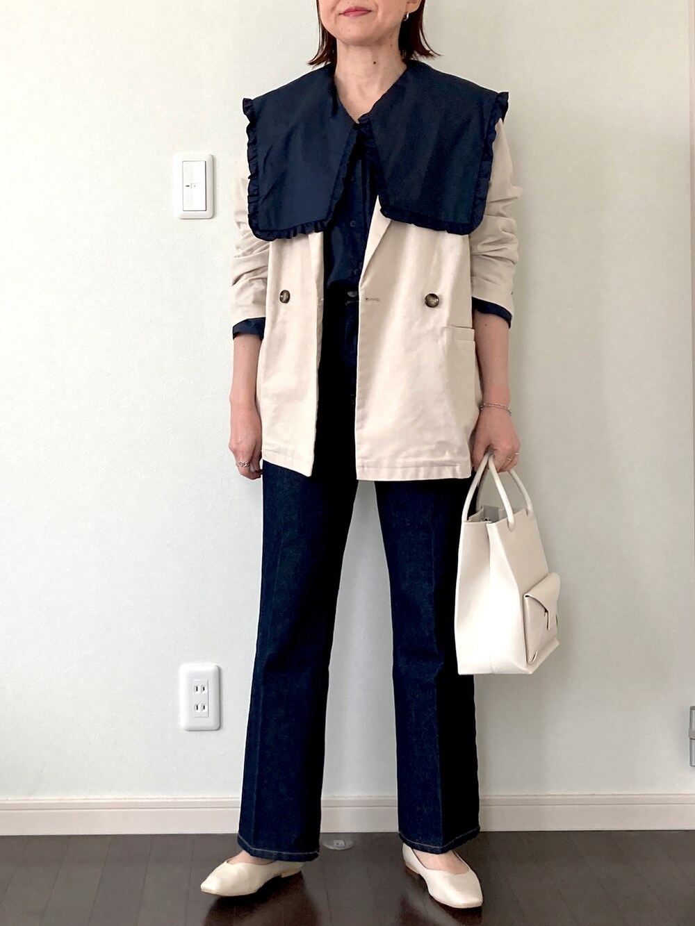 ブルー系のシャツ/ブラウス、ベージュ系のショルダーバッグ、ブルー系のデニムパンツを着用したレディースの春コーディネートの2枚目の写真
