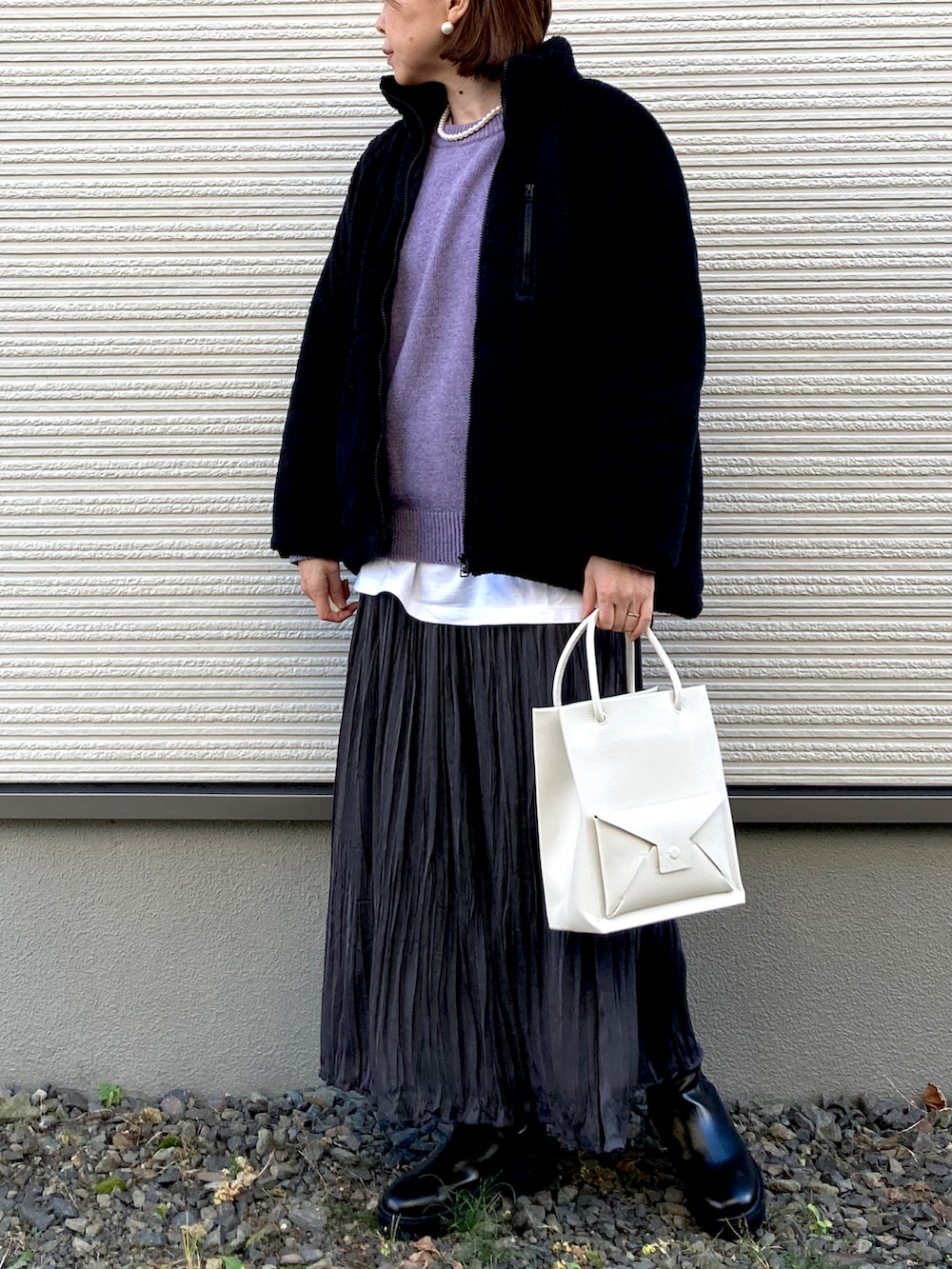 パープル系のニット/セーター、ホワイト系のTシャツ/カットソー、ベージュ系のショルダーバッグを着用したレディースの秋コーディネートの2枚目の写真
