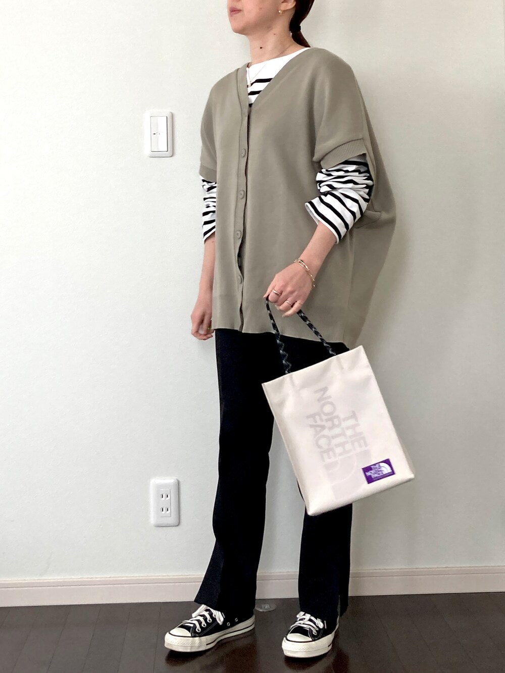 グリーン系のベスト、ホワイト系のTシャツ/カットソー、ホワイト系のトートバッグを着用したレディースの冬コーディネートの3枚目の写真