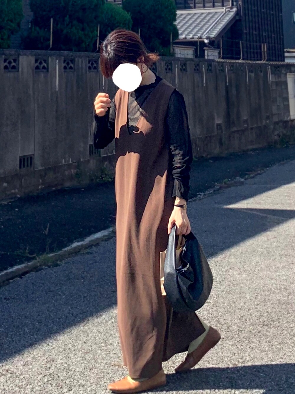 ブラック系のショルダーバッグ、ブラウン系のパンプス、ブラック系のTシャツ/カットソーを着用したレディースの秋コーディネートの2枚目の写真