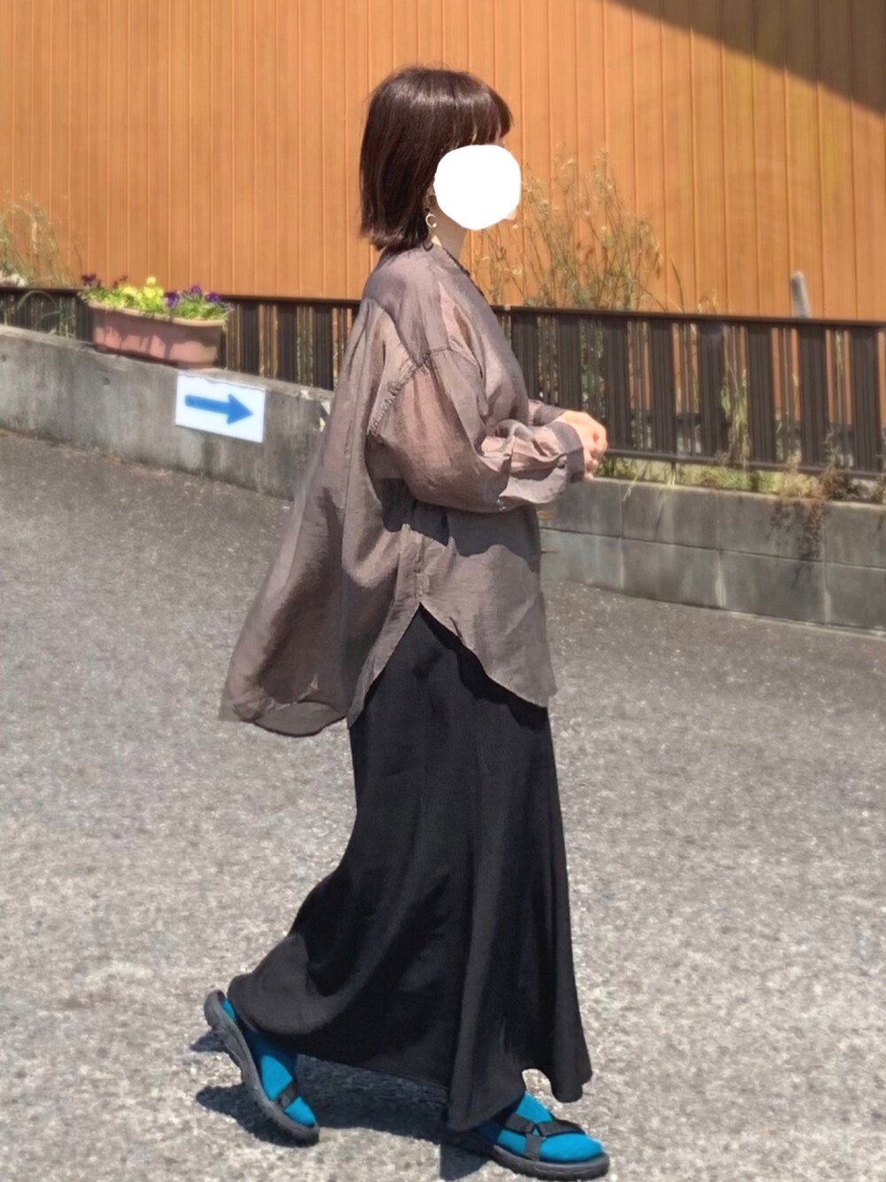 ブラック系のスカート、ブラウン系のシャツ/ブラウス、ブラック系のサンダルを着用したレディースの夏コーディネートの2枚目の写真