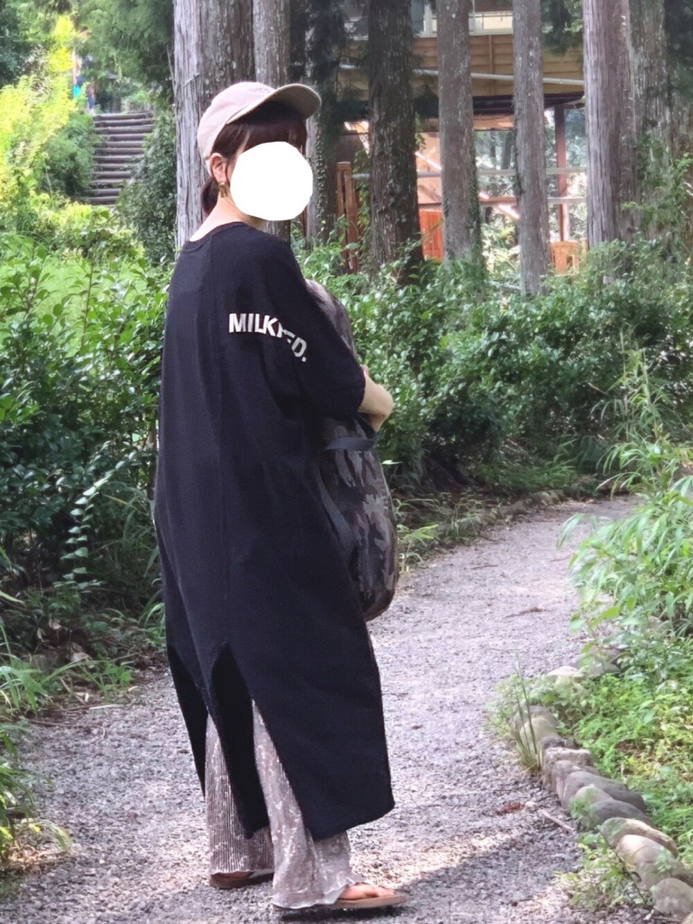 ブラック系のワンピース/ドレス、ホワイト系のサンダル、ベージュ系のキャップを着用したレディースの秋コーディネートの2枚目の写真