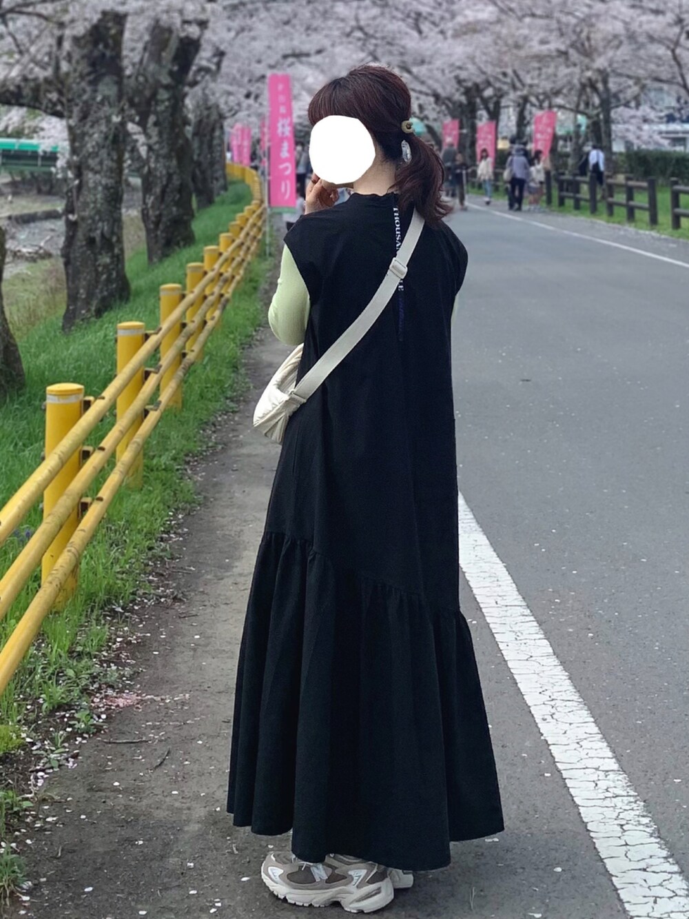 ベージュ系のスニーカー、ブラック系のワンピース、ブルー系のTシャツ/カットソーを着用したレディースの春コーディネートの2枚目の写真
