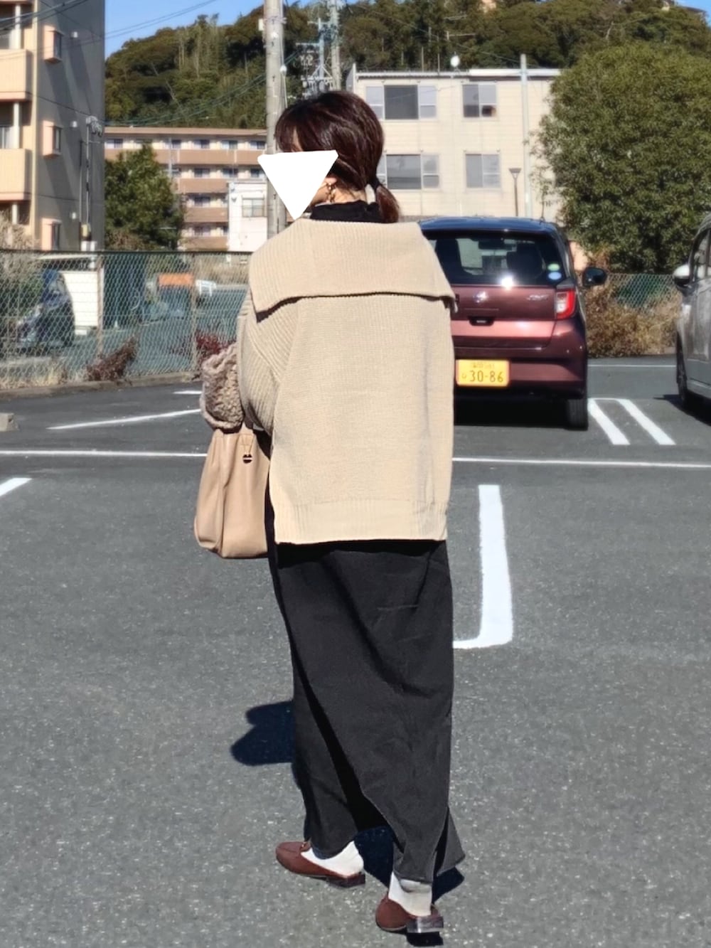 ブラウン系のローファー、ブラック系のスカート、ベージュ系のニット/セーターを着用したレディースの冬コーディネートの2枚目の写真