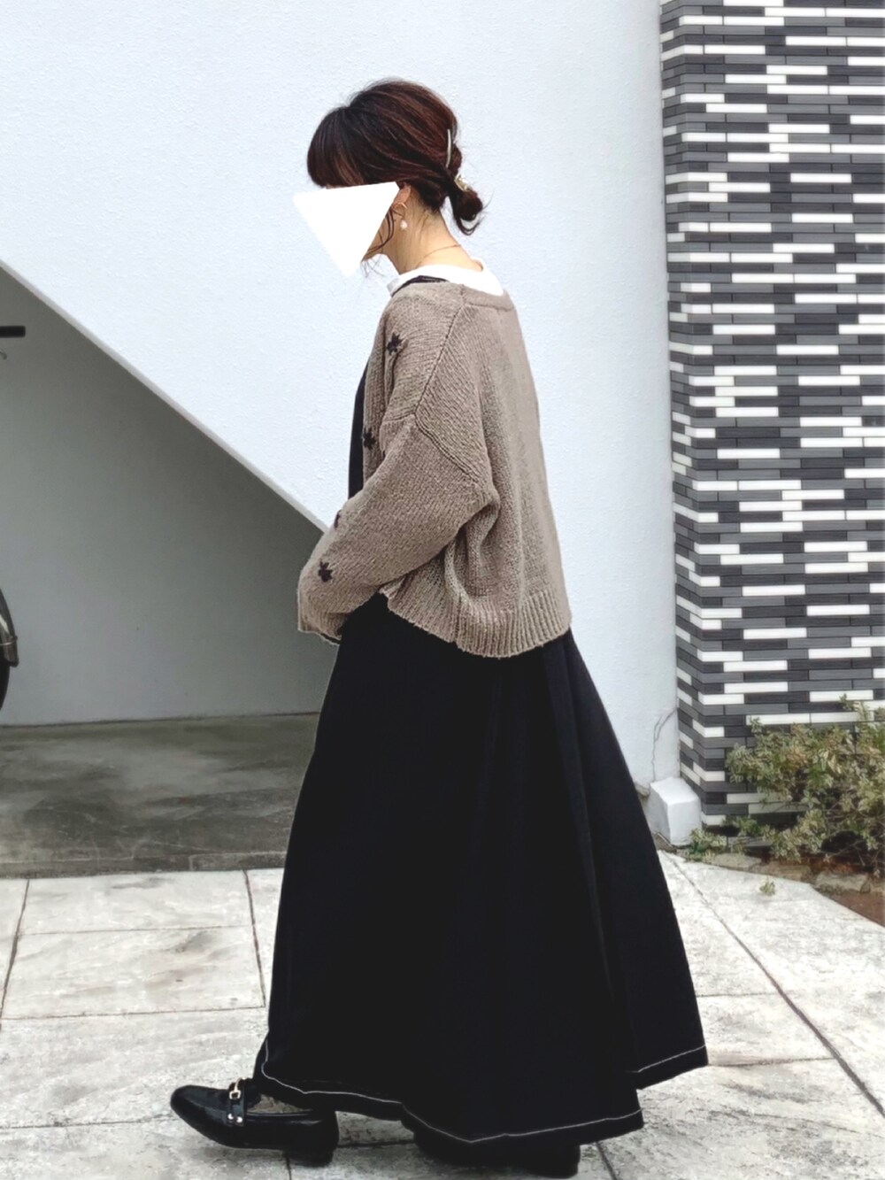 ブラック系のローファー、グレー系のカーディガン/ボレロ、ブラック系のジャンパースカートを着用したレディースの春コーディネートの2枚目の写真