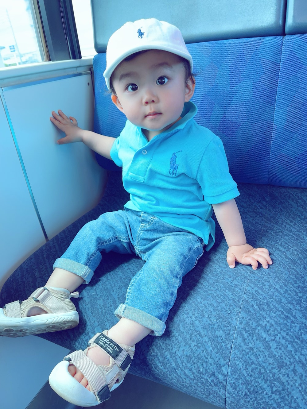 ブルー系のポロシャツ、ブルー系のデニムパンツ、ベージュ系のサンダルを着用したキッズの夏コーディネートの2枚目の写真