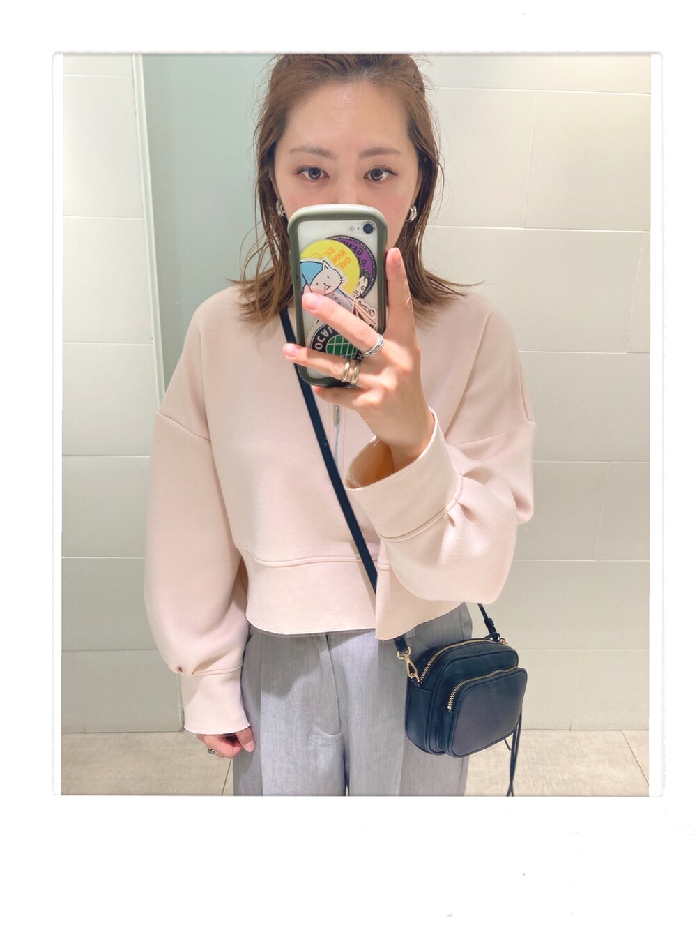 グレー系のスラックス、ブラック系のサンダル、ブラック系のショルダーバッグを着用したレディースの春コーディネートの2枚目の写真