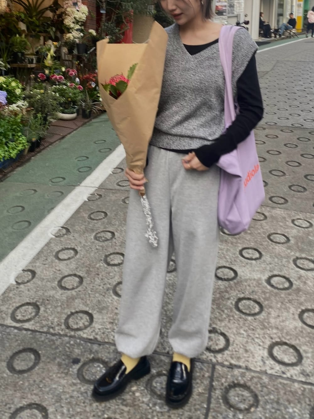 グレー系のスウェットパンツ、ブラック系のローファー、パープル系のトートバッグを着用したレディースの春コーディネートの3枚目の写真