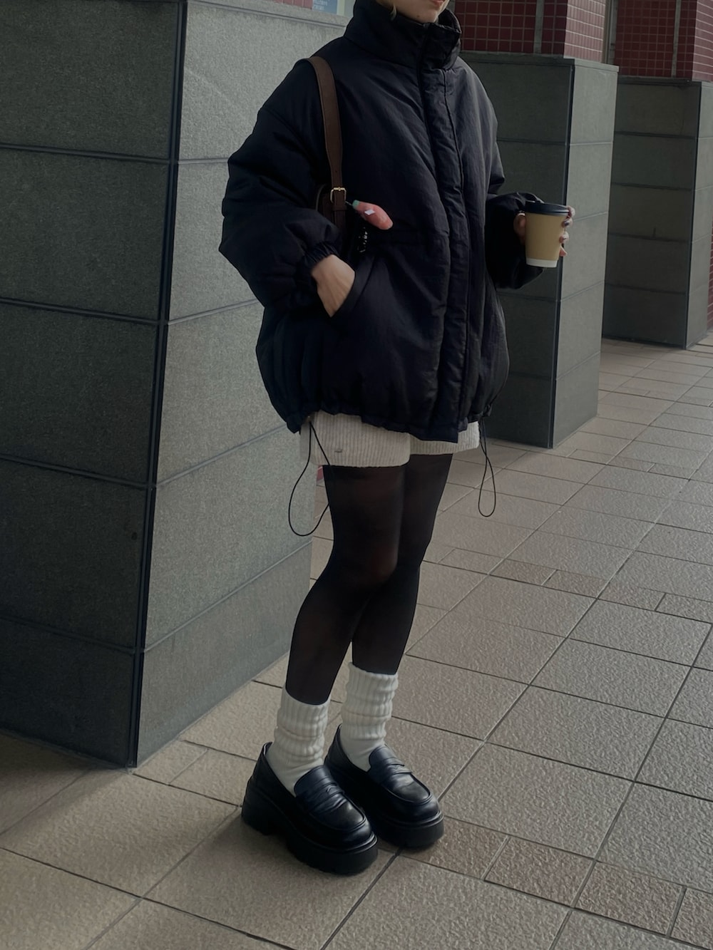 ブラック系のブルゾン、ホワイト系のその他パンツ、ブラック系のローファーを着用したレディースの秋コーディネートの2枚目の写真