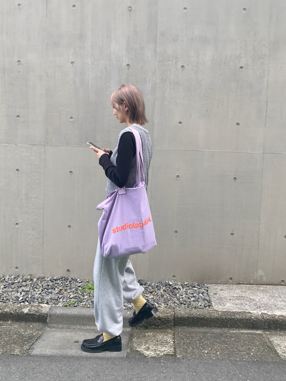 グレー系のスウェットパンツ、ブラック系のローファー、パープル系のトートバッグを着用したレディースの春コーディネートの2枚目の写真