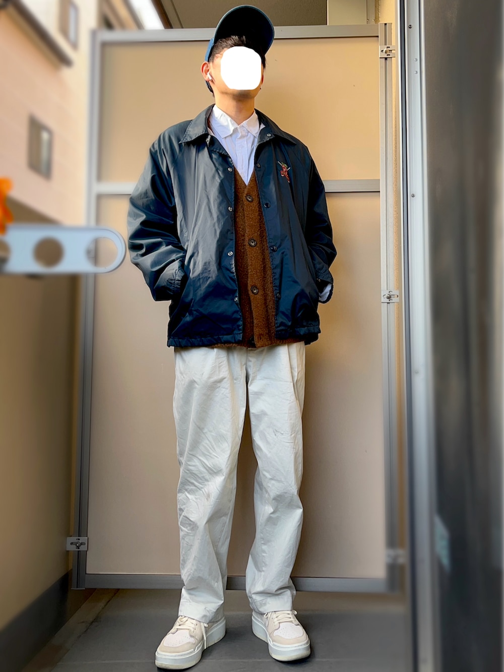ホワイト系のシャツ/ブラウス、ベージュ系のスニーカー、ブルー系のナイロンジャケットを着用したメンズの冬コーディネートの2枚目の写真