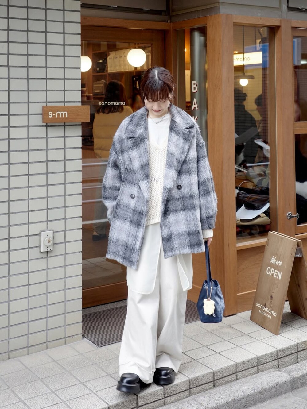 ホワイト系のトップス、ホワイト系のパンツ、ブルー系のバッグを着用したレディースの春コーディネートの4枚目の写真