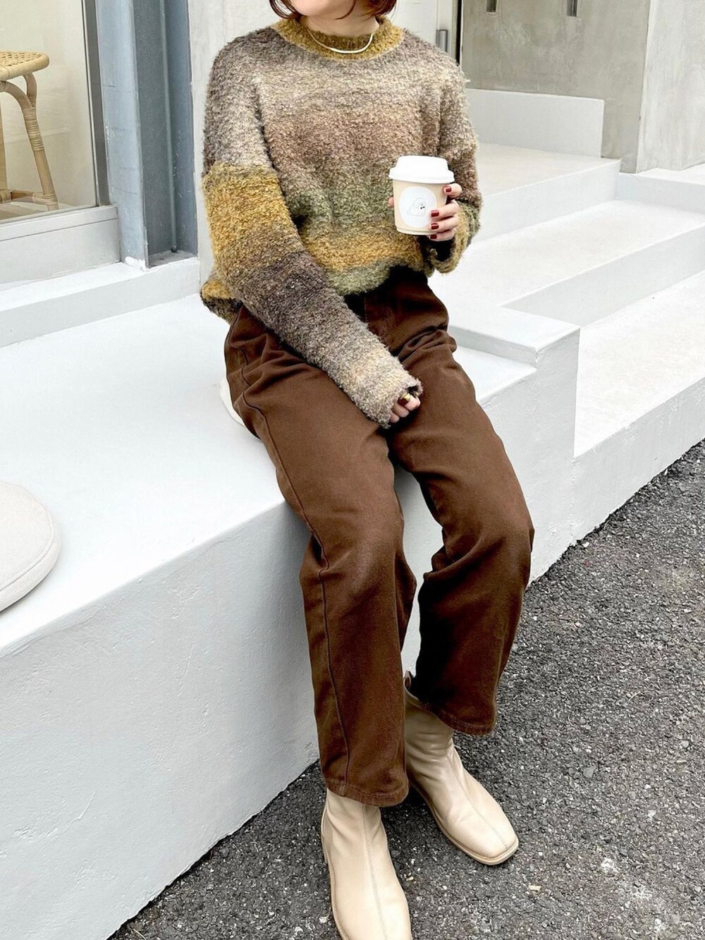 ブラウン系のパンツ、ベージュ系のニット/セーターを着用したレディースの冬コーディネートの2枚目の写真
