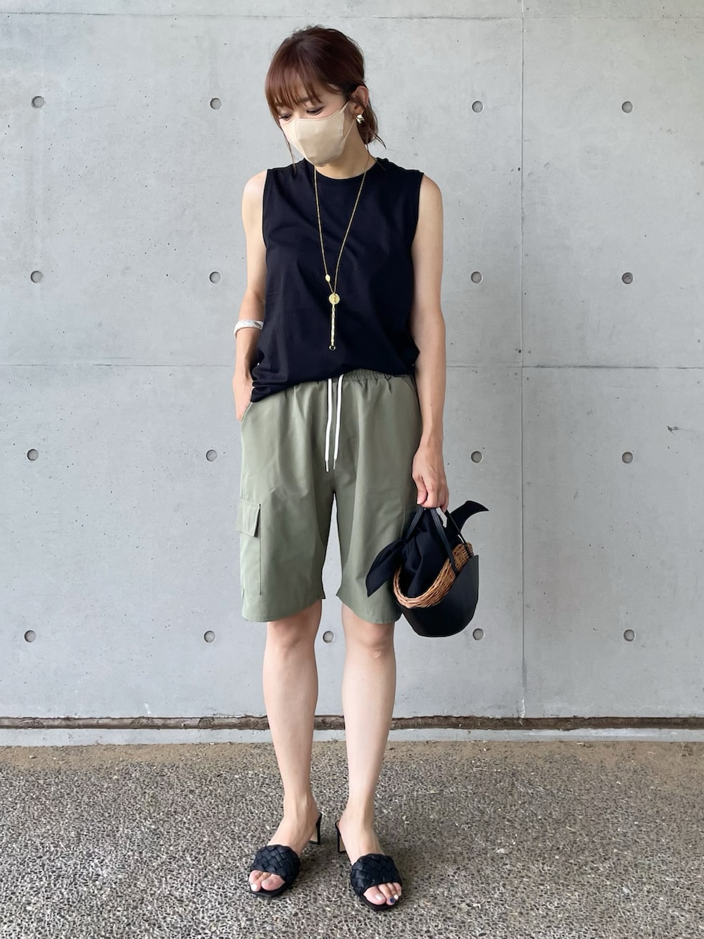 ブラック系のタンクトップ、グリーン系のパンツ、ブラック系のかごバッグを着用したレディースの夏コーディネートの2枚目の写真