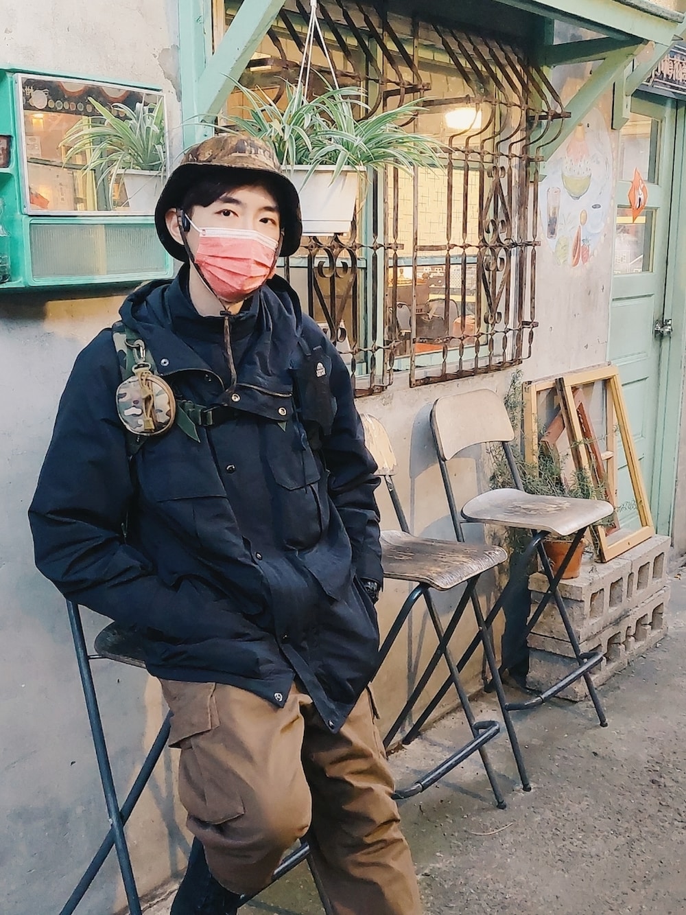 ブラウン系のカーゴパンツ、ブラック系のマウンテンパーカーを着用したメンズの夏コーディネートの2枚目の写真