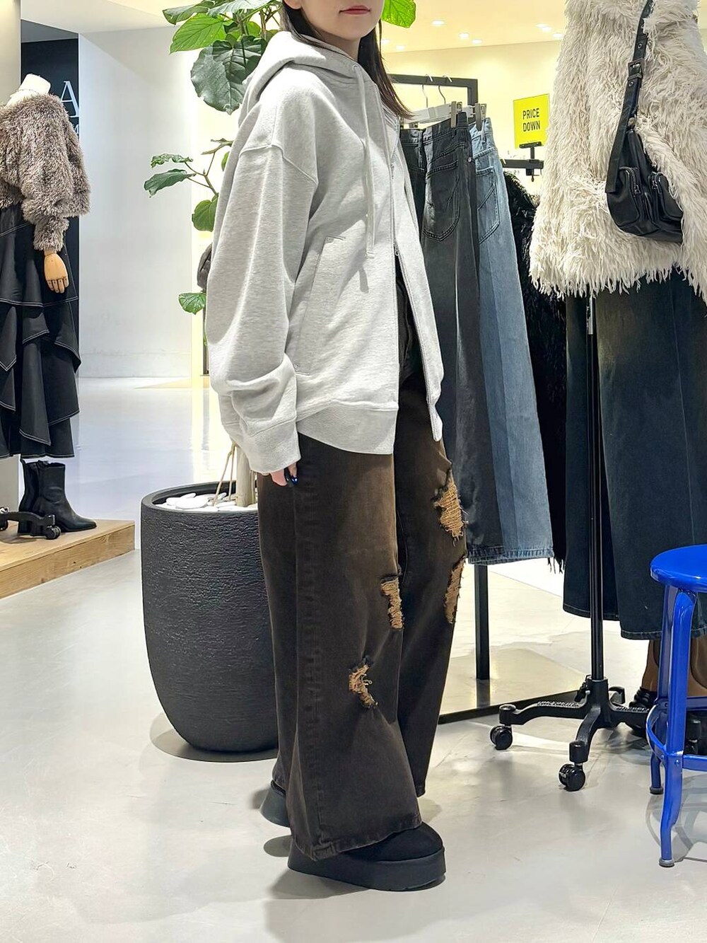 ブラック系のショルダーバッグ、グレー系のパーカー、ブラック系のブーツを着用したレディースの冬コーディネートの5枚目の写真