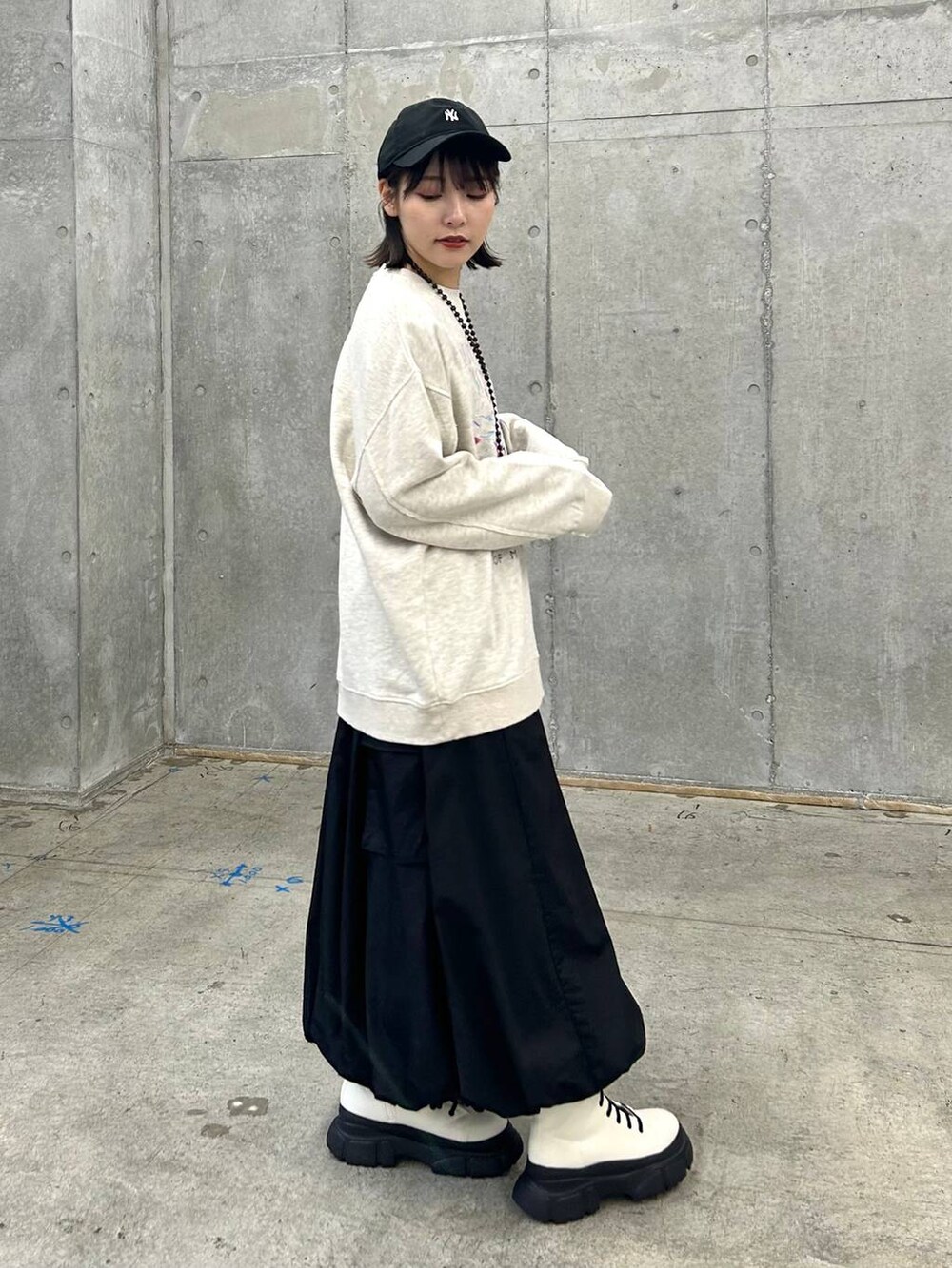 ベージュ系のスウェット、ベージュ系のボストンバッグ、ホワイト系のブーツを着用したレディースの冬コーディネートの4枚目の写真