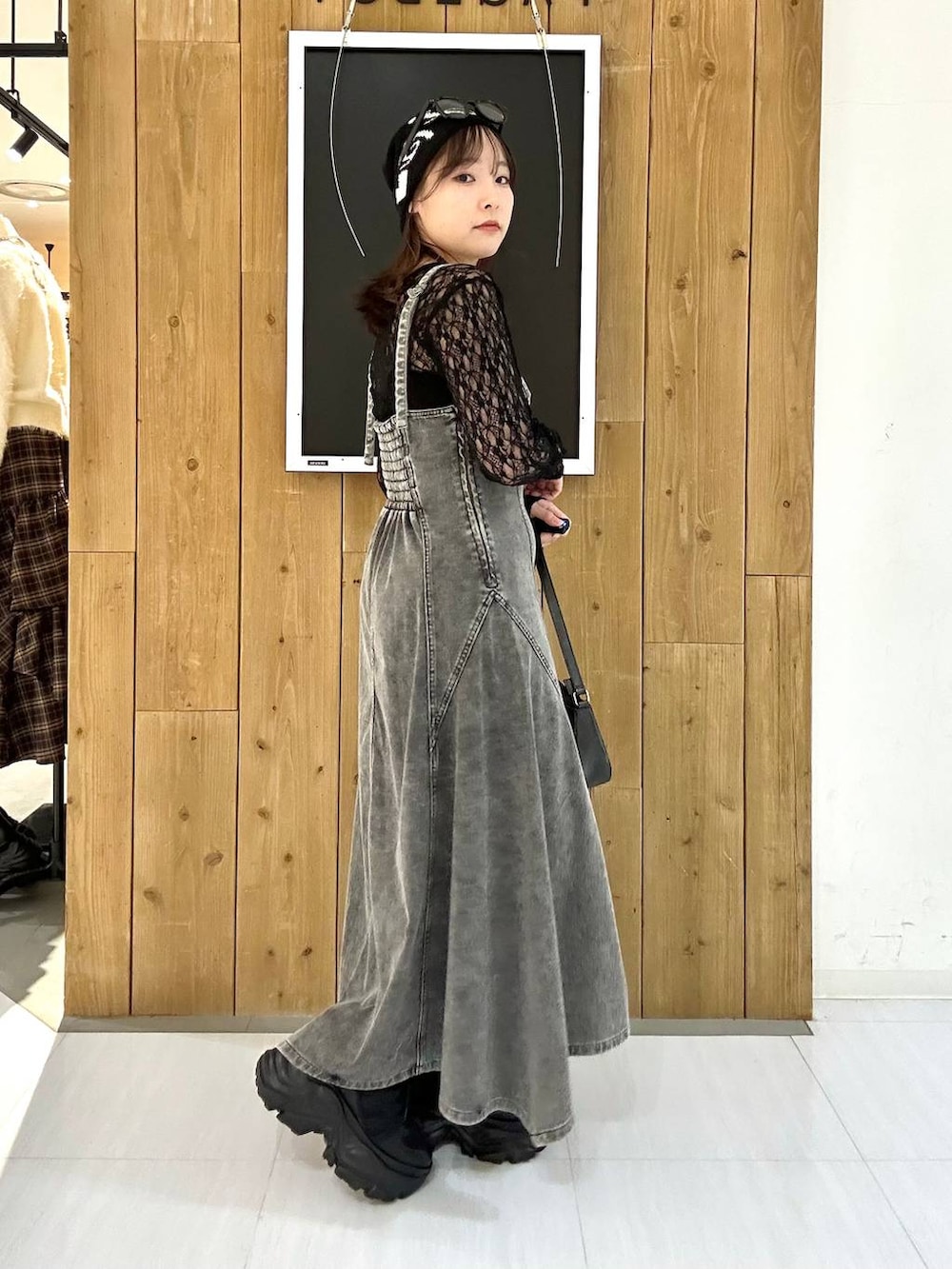 ブラック系のスニーカー、ブラック系のTシャツ/カットソー、ブラック系のハンドバッグを着用したレディースの冬コーディネートの5枚目の写真