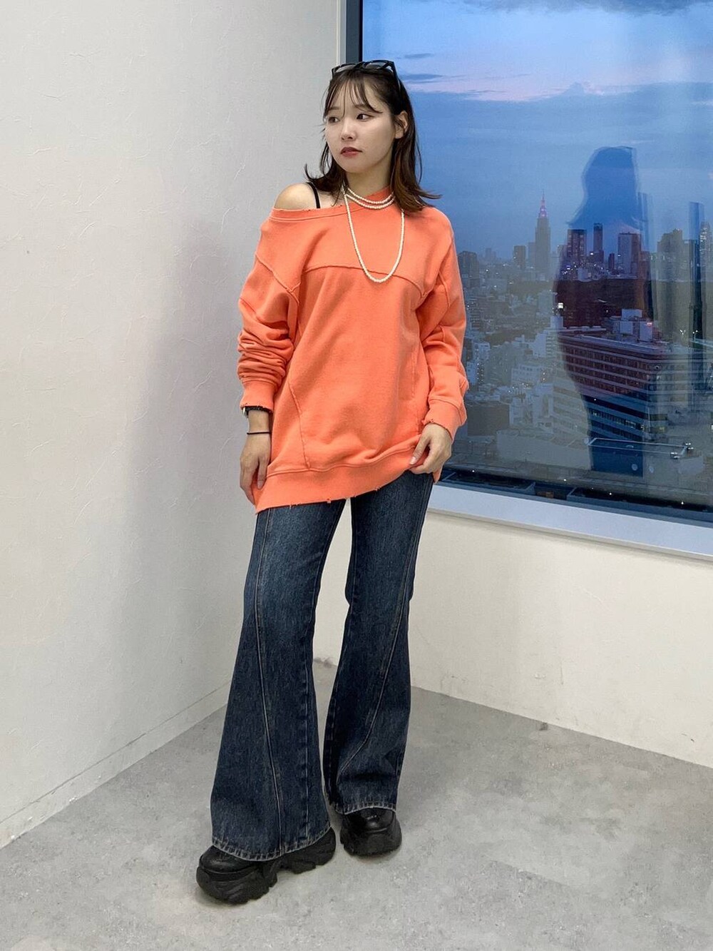 ブルー系のデニムパンツ、ピンク系のスウェットを着用したレディースの秋コーディネートの2枚目の写真