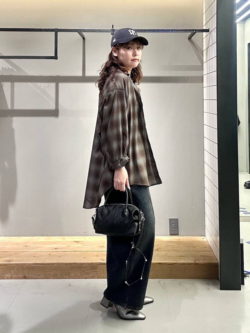 ブラック系のシャツ/ブラウス、ブルー系のデニムパンツ、ブラック系のショルダーバッグを着用したレディースの秋コーディネートの5枚目の写真