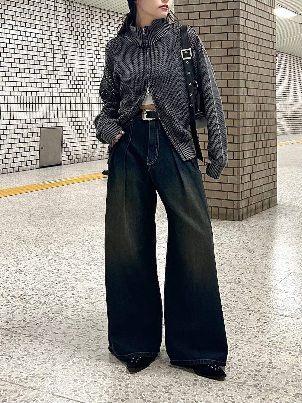 ブルー系のデニムパンツ、ブラック系のパンプス、ブラック系のショルダーバッグを着用したレディースの春コーディネートの3枚目の写真