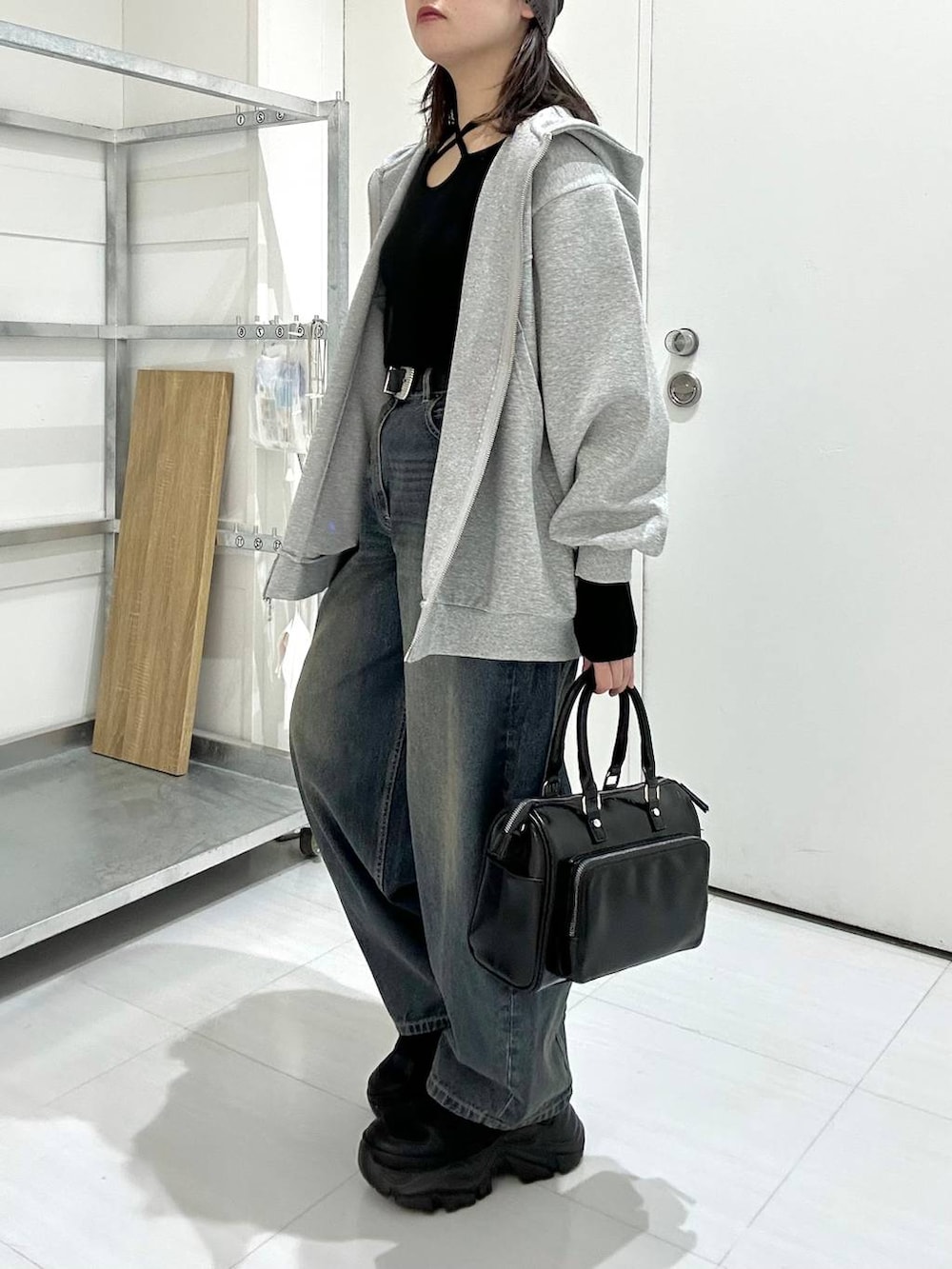 ブラック系のスニーカー、グレー系のパーカー、ブラック系のニット/セーターを着用したレディースの冬コーディネートの4枚目の写真