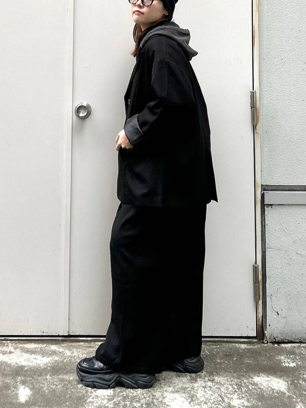 ブラック系のスニーカー、ブラック系のパーカー、ブラック系のテーラードジャケットを着用したレディースの秋コーディネートの6枚目の写真