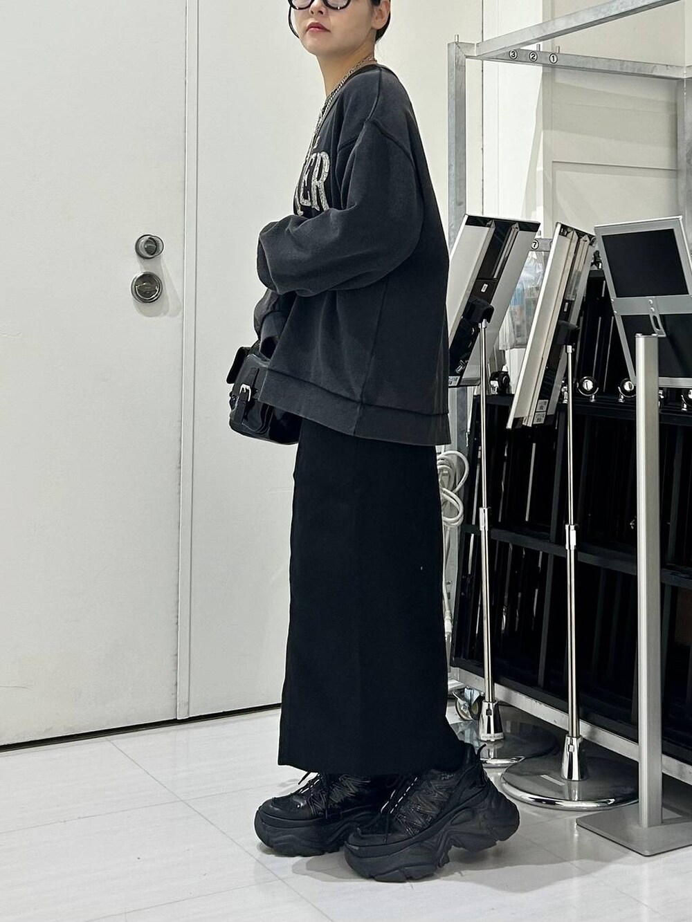 ブラック系のショルダーバッグ、グレー系のスウェット、ブラック系のスカートを着用したレディースの秋コーディネートの4枚目の写真