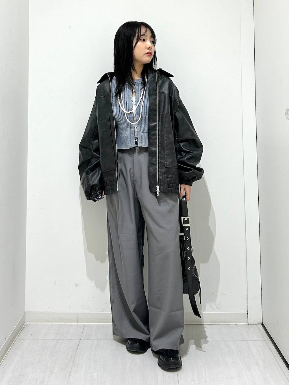 ブラック系のブルゾン、ブラック系のスニーカー、ブラック系のショルダーバッグを着用したレディースの春コーディネートの2枚目の写真