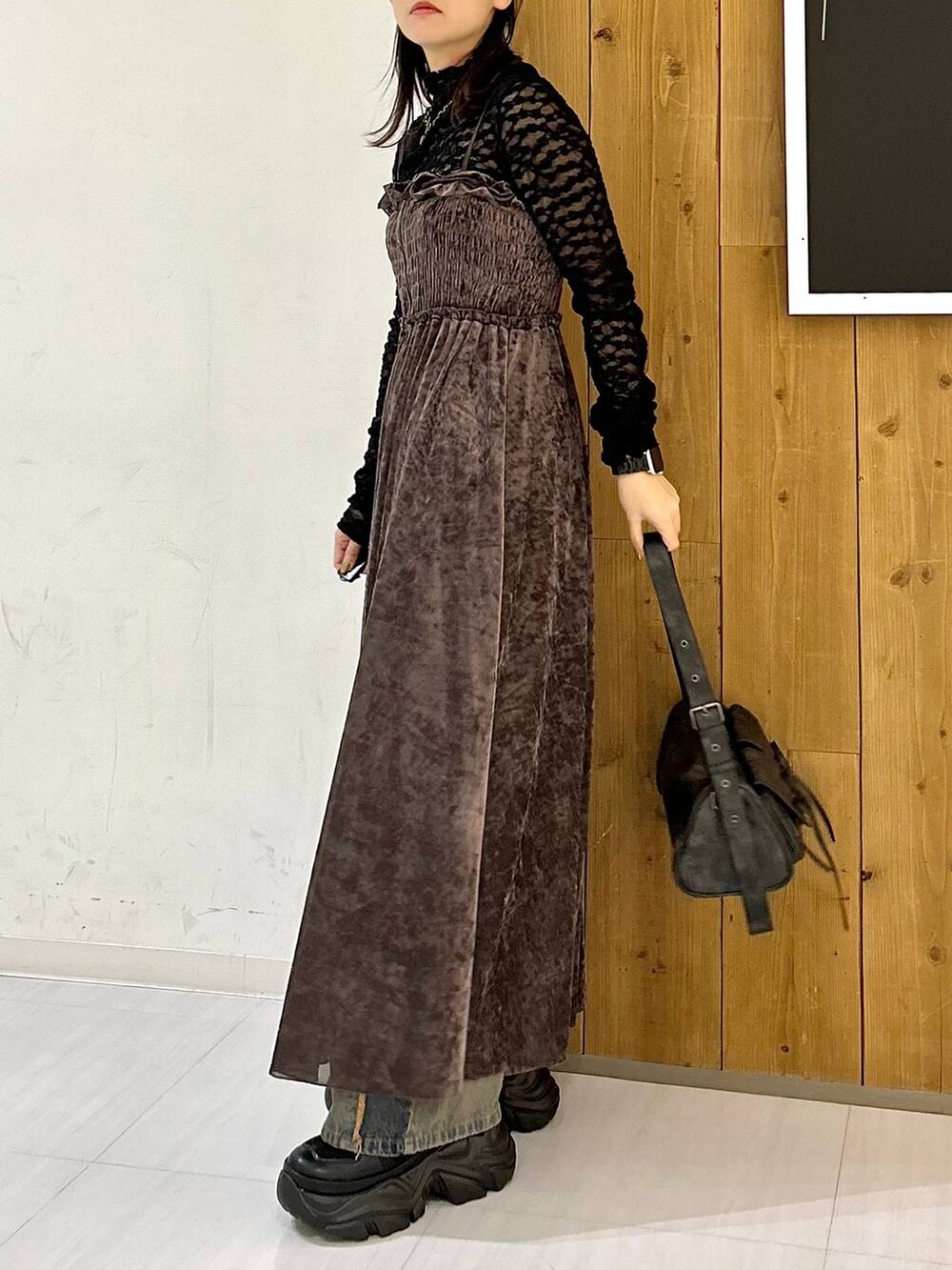 ブルー系のデニムパンツ、ブラック系のブーツ、ブラック系のキャミソールを着用したレディースの秋コーディネートの6枚目の写真