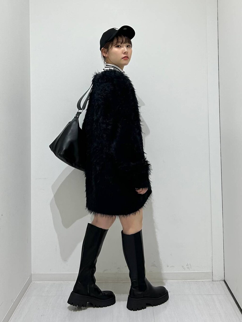 ブラック系のカーディガン/ボレロ、ブラック系のブーツ、ブラック系のショルダーバッグを着用したレディースの秋コーディネートの5枚目の写真