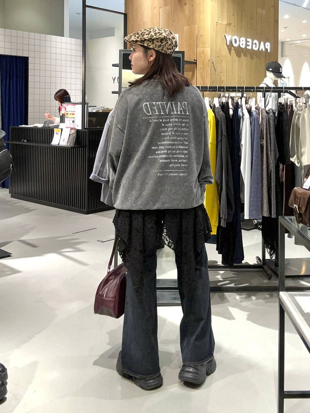 ブラック系のスニーカー、ブラック系のデニムパンツ、レッド系のボストンバッグを着用したレディースの秋コーディネートの7枚目の写真