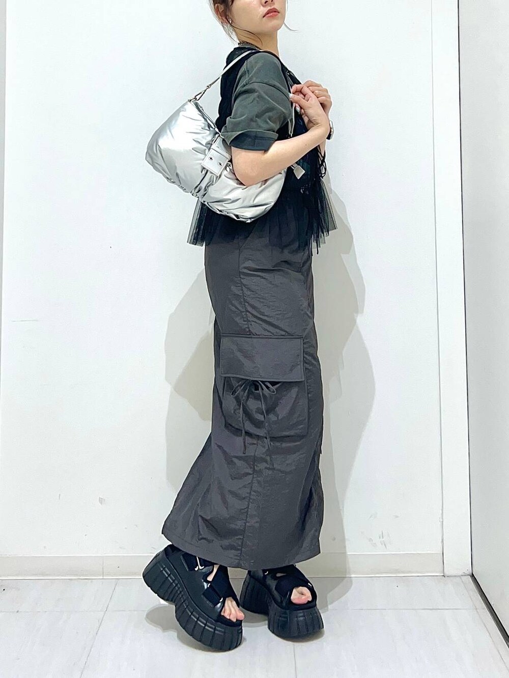 ブラック系のスニーカー、グレー系のTシャツ/カットソー、シルバー系のショルダーバッグを着用したレディースの夏コーディネートの6枚目の写真