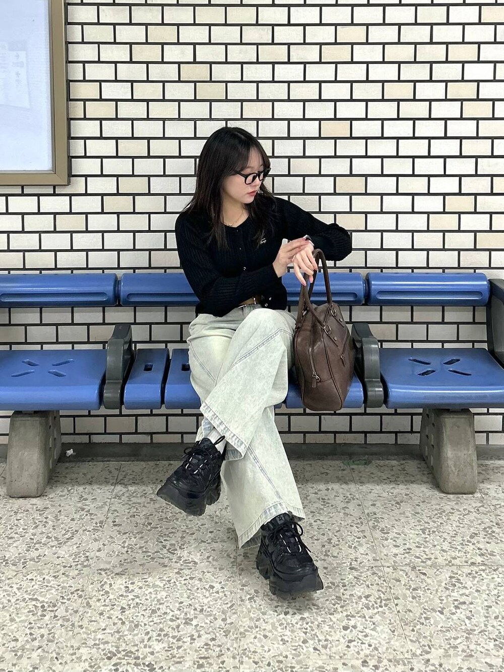 ブラック系のスニーカー、ブルー系のデニムパンツ、ブラウン系のボストンバッグを着用したレディースの夏コーディネートの9枚目の写真