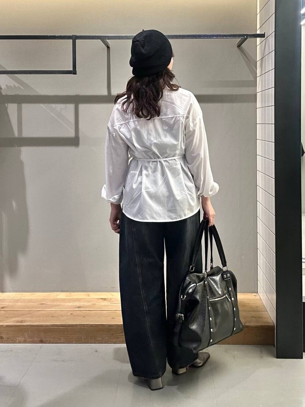 ブラック系のボストンバッグ、ブルー系のデニムパンツ、ホワイト系のシャツ/ブラウスを着用したレディースの秋コーディネートの5枚目の写真