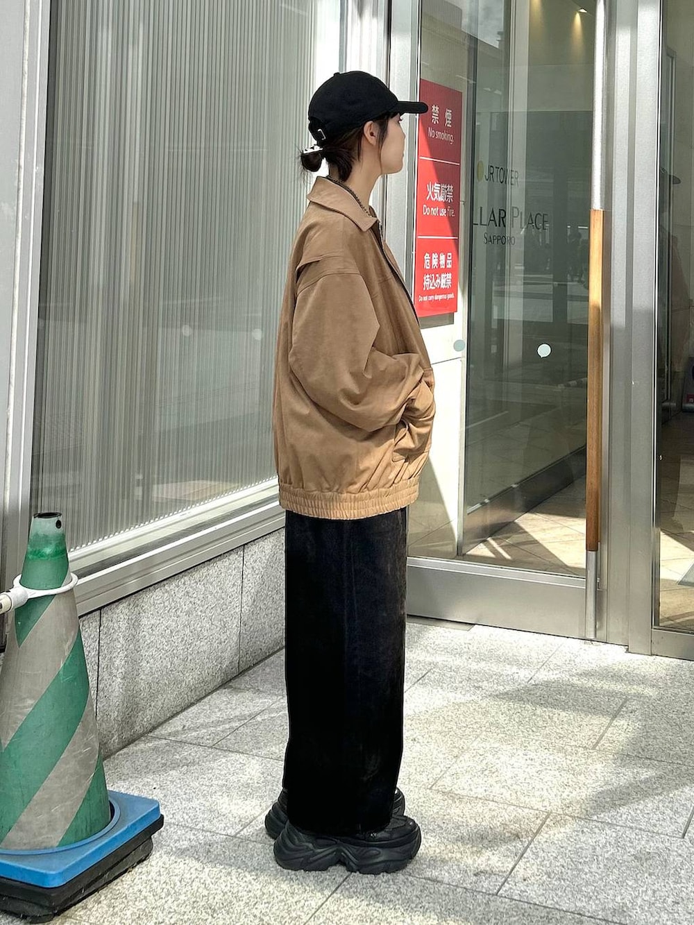 ブラック系のデニムパンツ、イエロー系のブルゾン、ブラック系のTシャツ/カットソーを着用したレディースの秋コーディネートの5枚目の写真