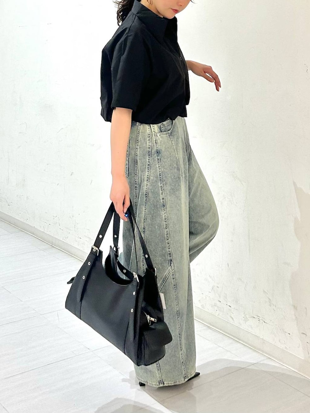 ブルー系のデニムパンツ、ブラック系のサンダル、ブラック系のベルトを着用したレディースの夏コーディネートの7枚目の写真