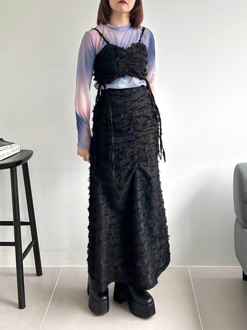 ブラック系のワンピース、ピンク系のTシャツ/カットソー、ブラック系のブーツを着用したレディースの秋コーディネートの3枚目の写真