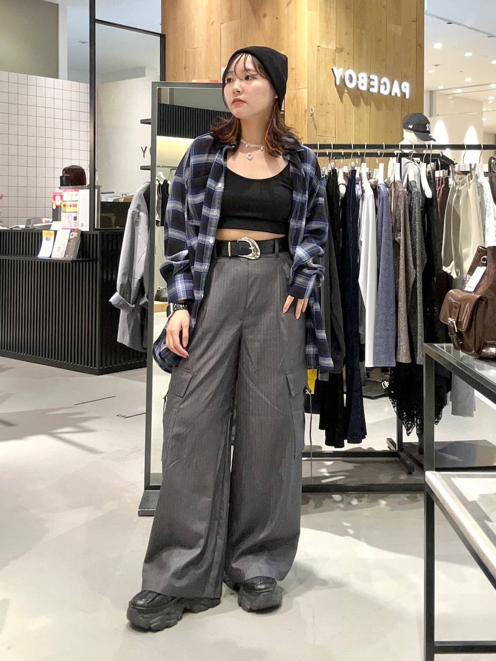 ブラック系のスニーカー、ブルー系のシャツ/ブラウス、グレー系のスラックスを着用したレディースの秋コーディネートの3枚目の写真