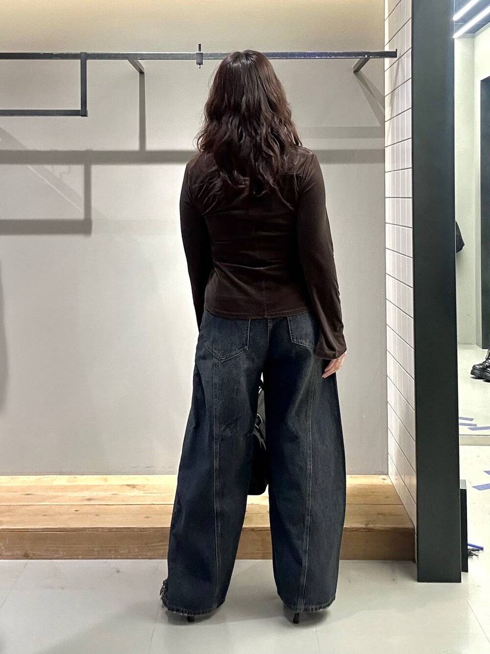 ブラック系のサンダル、ブルー系のデニムパンツ、ブラウン系のシャツ/ブラウスを着用したレディースの秋コーディネートの7枚目の写真