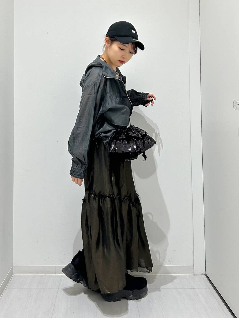 ブラック系のタンクトップ、ブラック系のスカート、グレー系のブルゾンを着用したレディースの春コーディネートの7枚目の写真