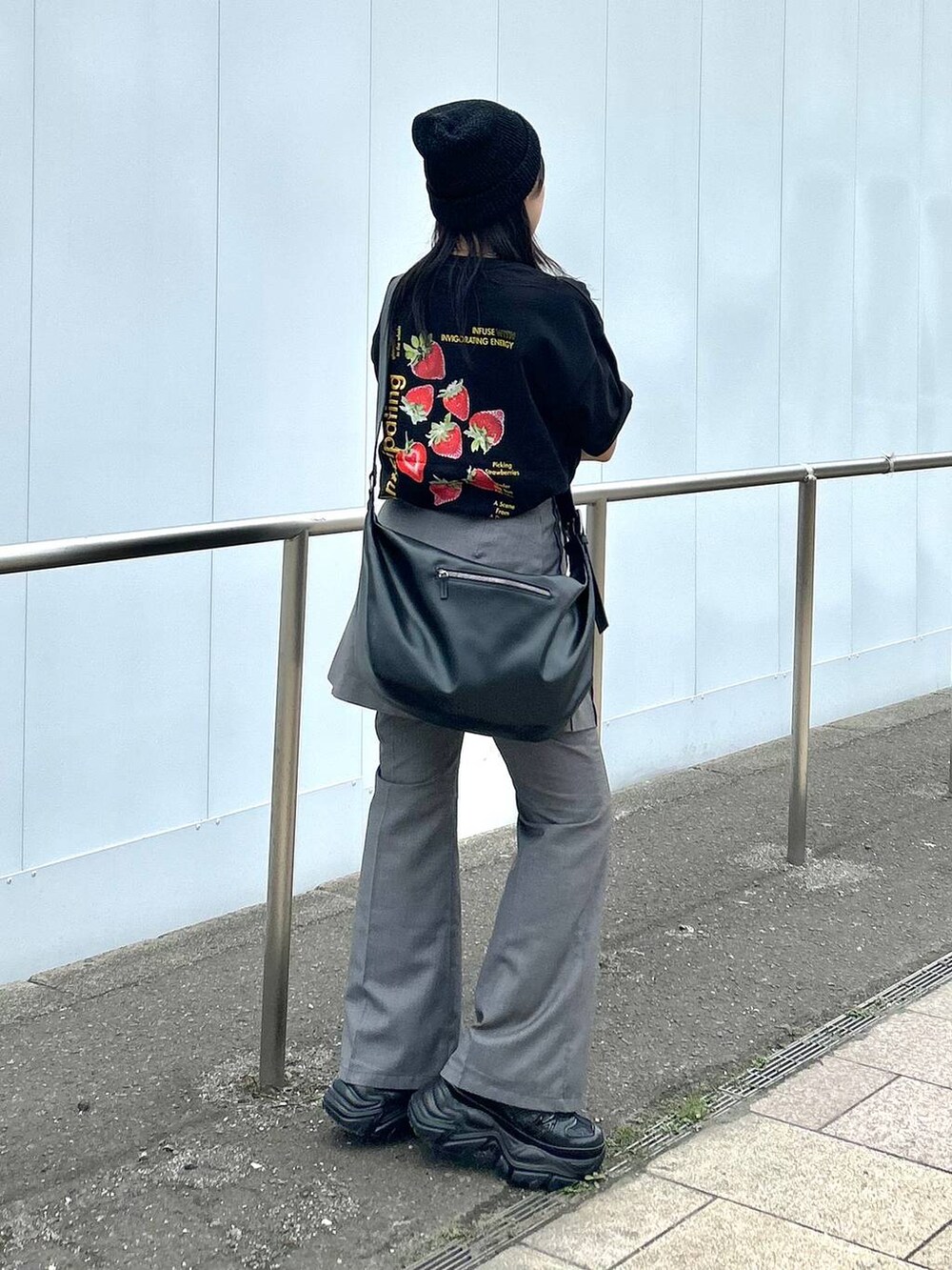 ブラック系のショルダーバッグ、グレー系のスカート、グレー系のスラックスを着用したレディースの春コーディネートの3枚目の写真