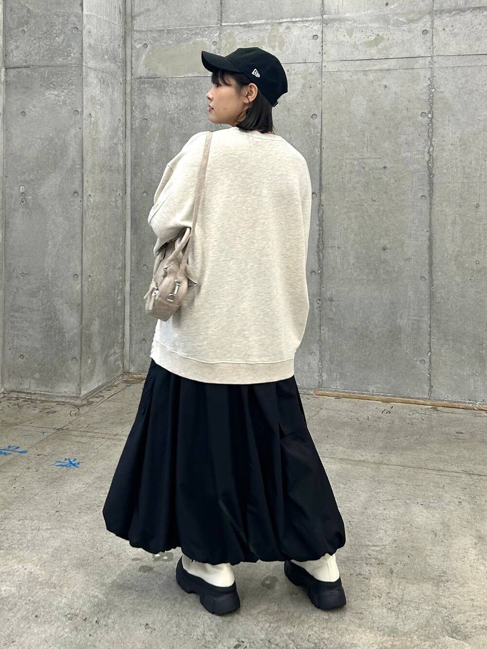 ベージュ系のスウェット、ベージュ系のボストンバッグ、ホワイト系のブーツを着用したレディースの冬コーディネートの5枚目の写真