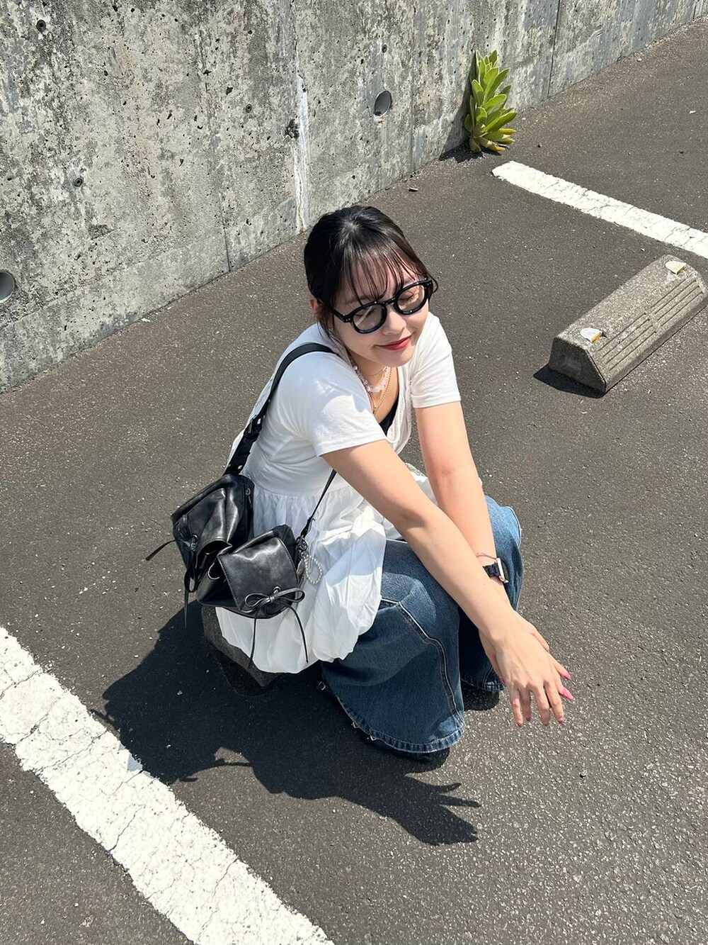 ブルー系のデニムパンツ、ホワイト系のTシャツ/カットソー、ホワイト系のキャミソールを着用したレディースの夏コーディネートの4枚目の写真