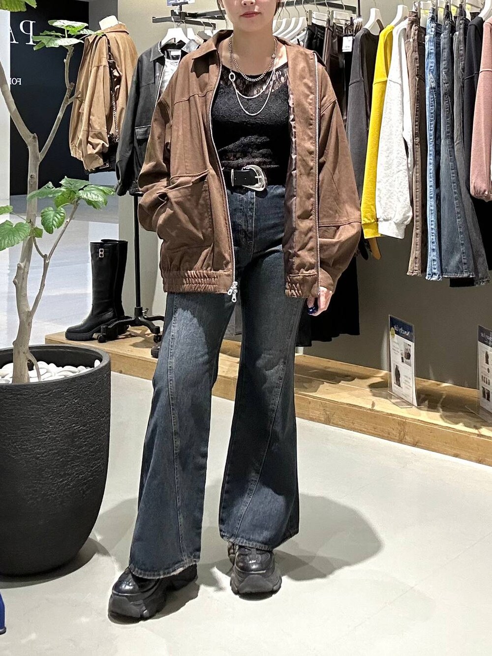 ブラック系のスニーカー、ブルー系のデニムパンツ、ブラック系のTシャツ/カットソーを着用したレディースの秋コーディネートの3枚目の写真