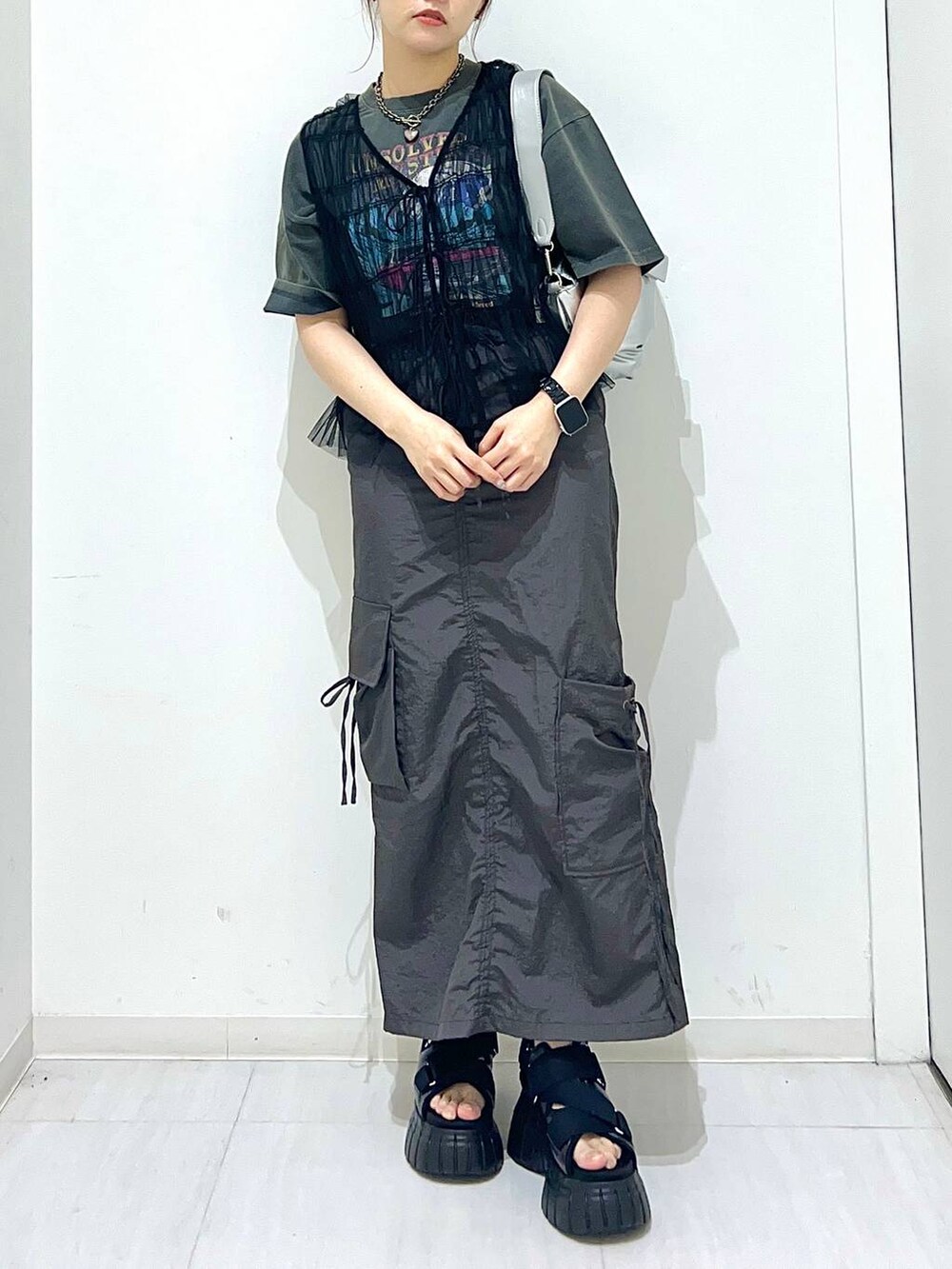 ブラック系のスニーカー、グレー系のTシャツ/カットソー、シルバー系のショルダーバッグを着用したレディースの夏コーディネートの3枚目の写真