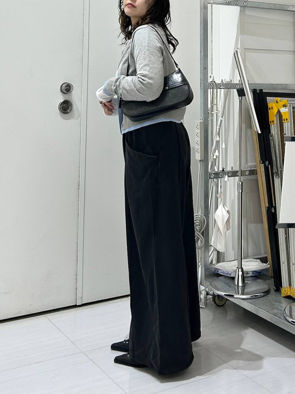 ブラック系のスウェットパンツ、グレー系のカーディガン/ボレロ、ホワイト系のTシャツ/カットソーを着用したレディースの冬コーディネートの6枚目の写真