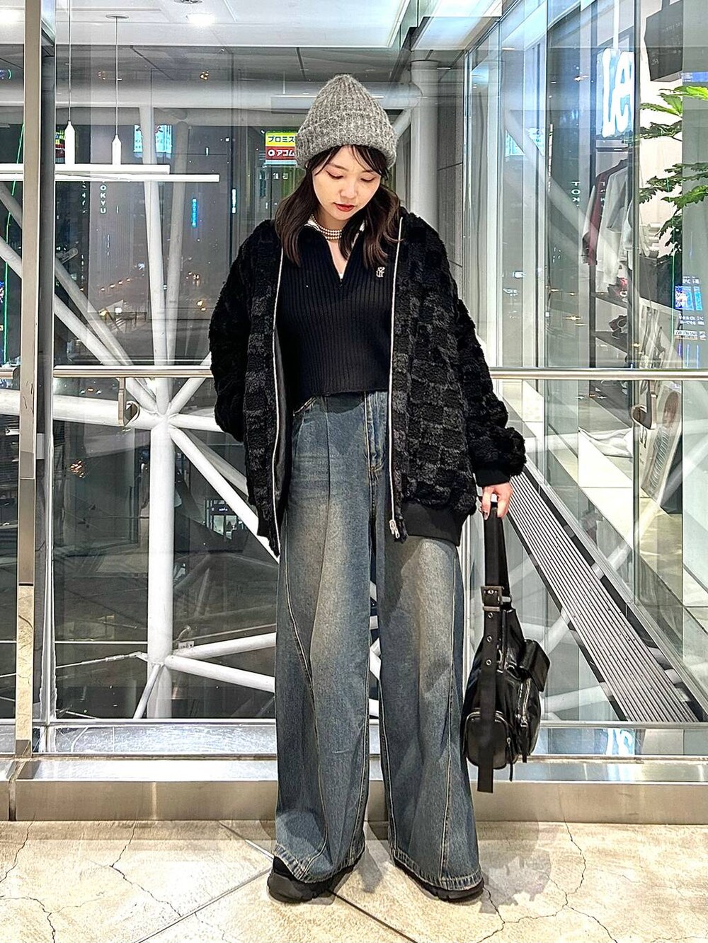 ブルー系のデニムパンツ、ブラック系のブルゾン、ブラック系のショルダーバッグを着用したレディースの秋コーディネートの2枚目の写真