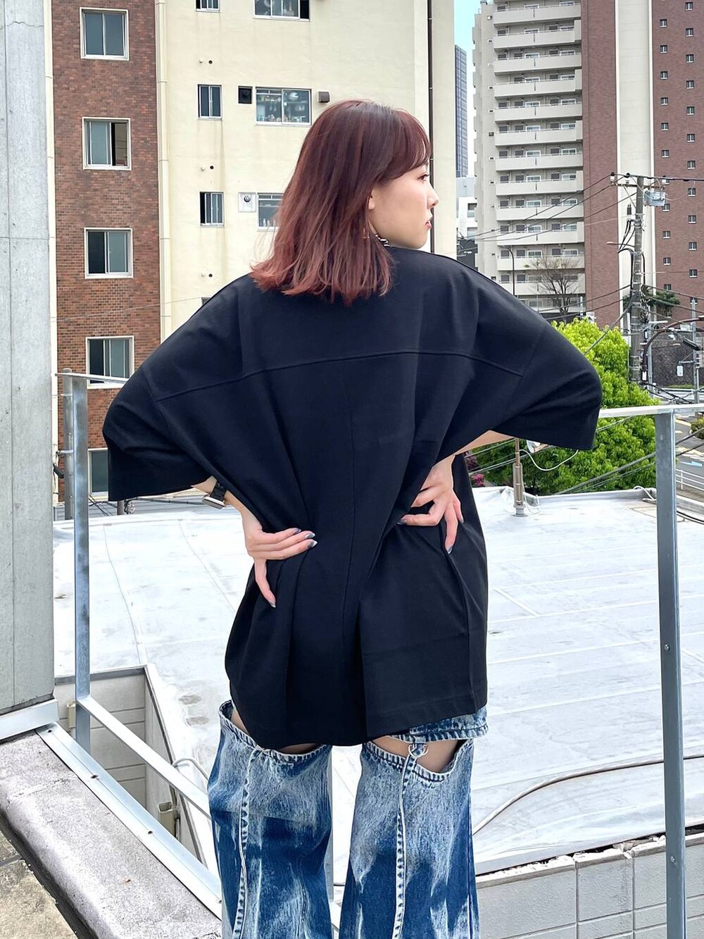 シルバー系のサンダル、シルバー系のショルダーバッグ、ブルー系のデニムパンツを着用したレディースの春コーディネートの4枚目の写真